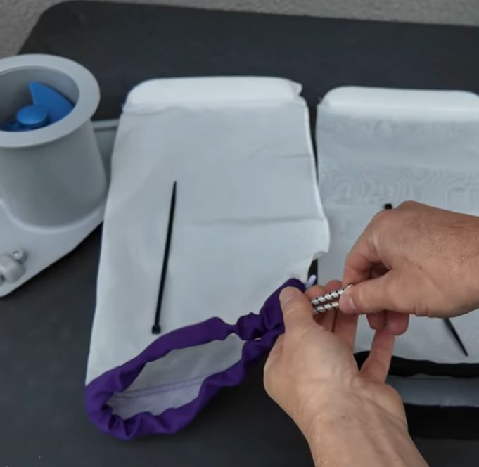 Clear Pool 45 Micron Micro Bag secured with bungee cord to pool vacuum showing attachment method