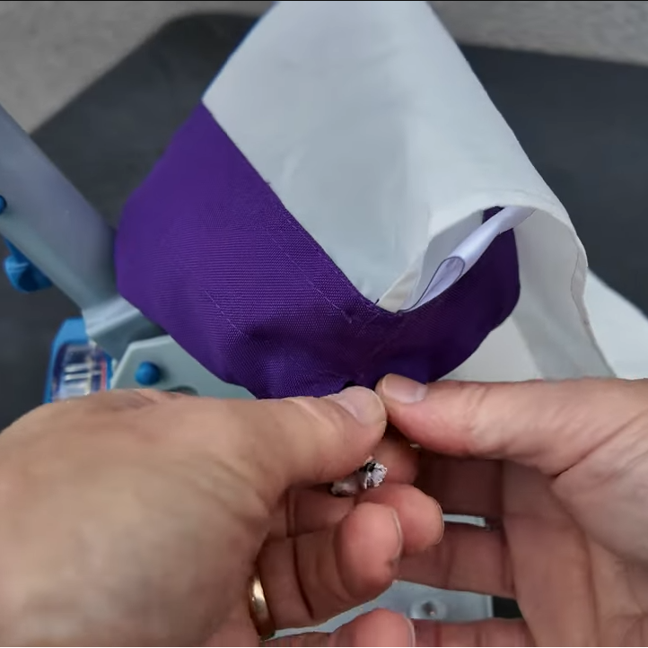 Hands tying the drawstring closure on a Clear Pool 45 Micron Micro Bag after emptying debris