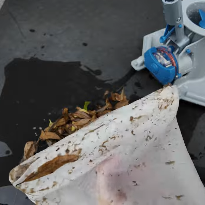 Clear Pool 45 Micron Micro Bag removed from pool vacuum with collected leaves and debris emptied onto ground